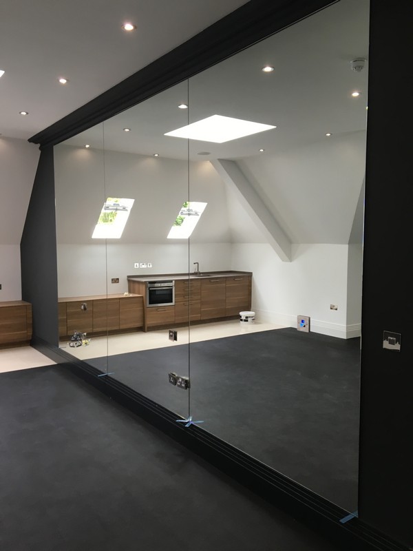 Frameless glass partition in loft conversion by Richmond glaziers
